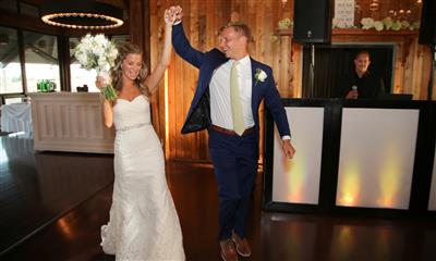 View Photo #2 - Bride and groom walking into reception room holding hands